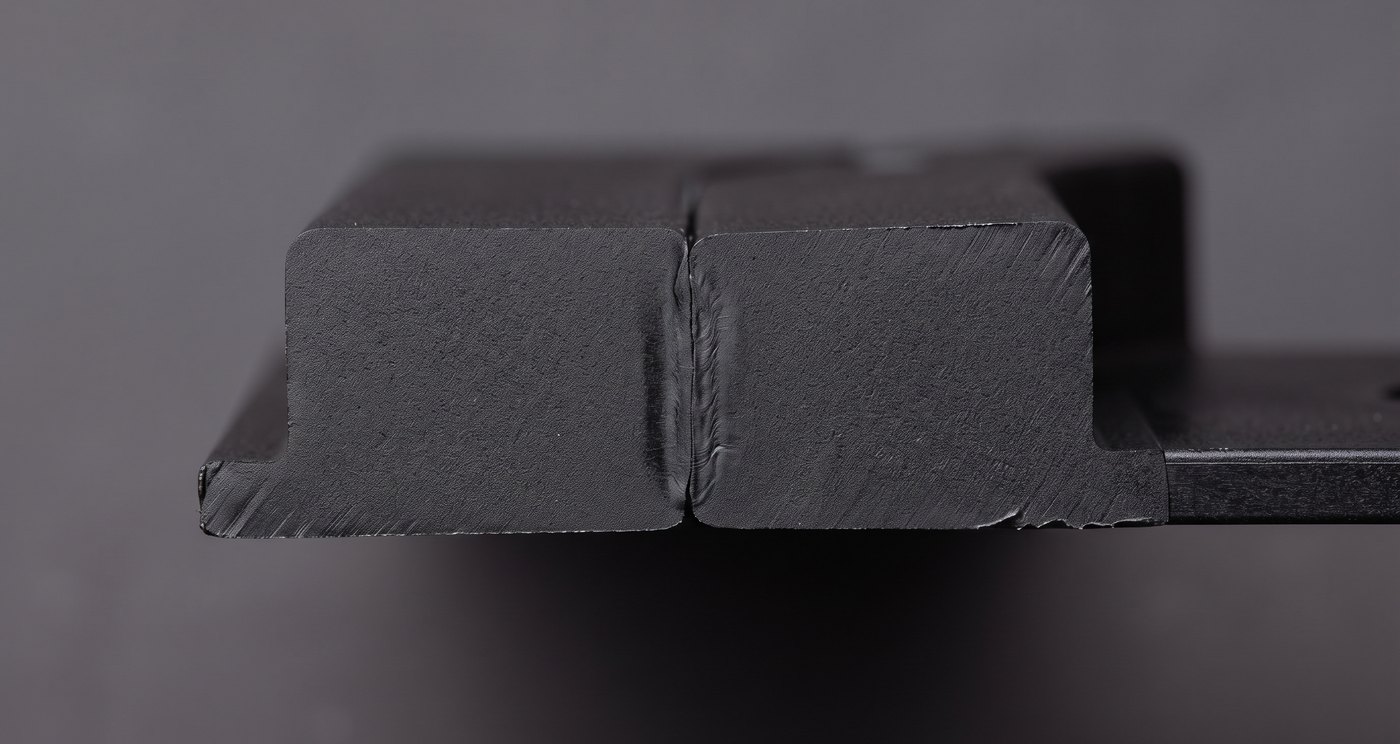Cross-section macro of two welded thermoplastic parts showing the fused joint line