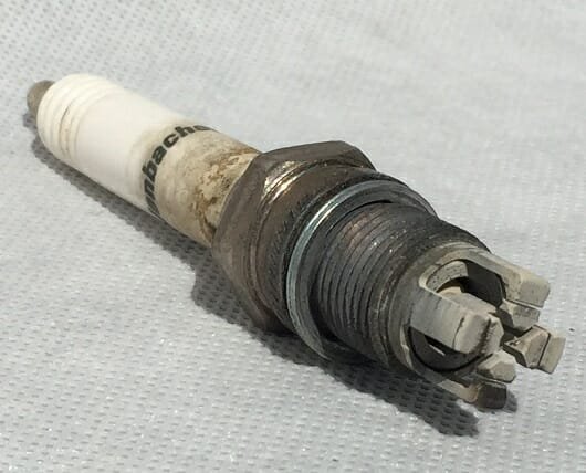 Gas engine spark plug fouled with combustion deposits