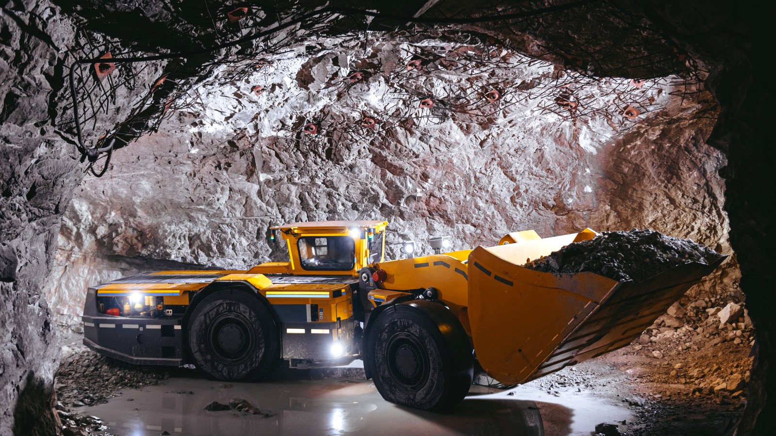 Underground loader carrying ore through a mine drive