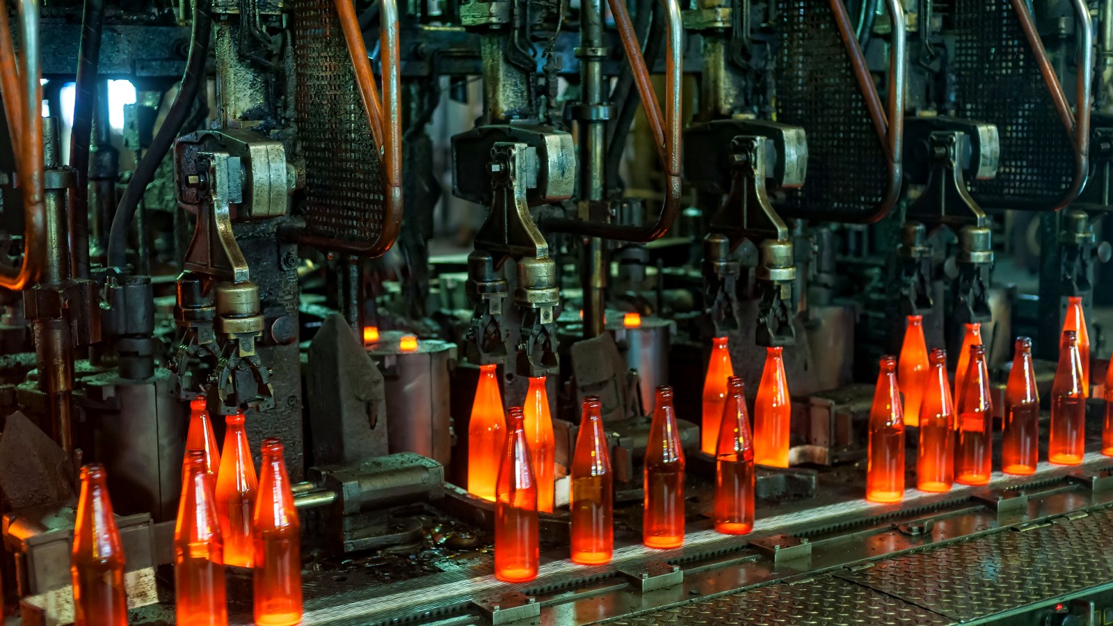 Glass bottles leaving the forming machine red-hot on the production line