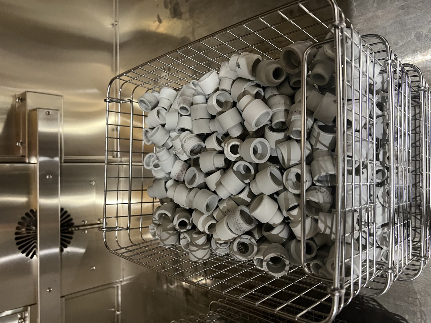 Ceramic insulator bushes basketed for ultrasonic cleaning
