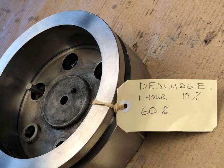 Die with a handwritten trial tag recording a one hour desludge cycle
