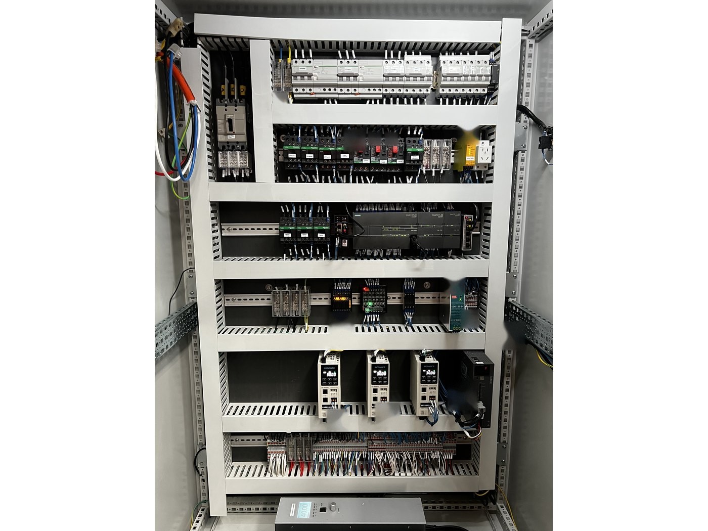 Control cabinet interior of a Misonics Sonos L-130 — breakers, contactors and I/O on DIN rail