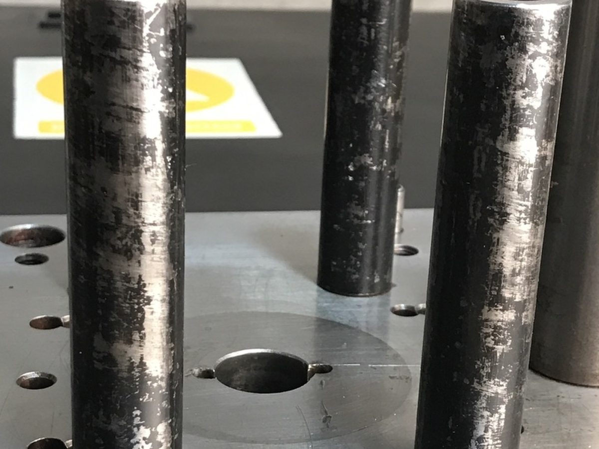 Ejector pins in a die plate — before and after ultrasonic cleaning — as received