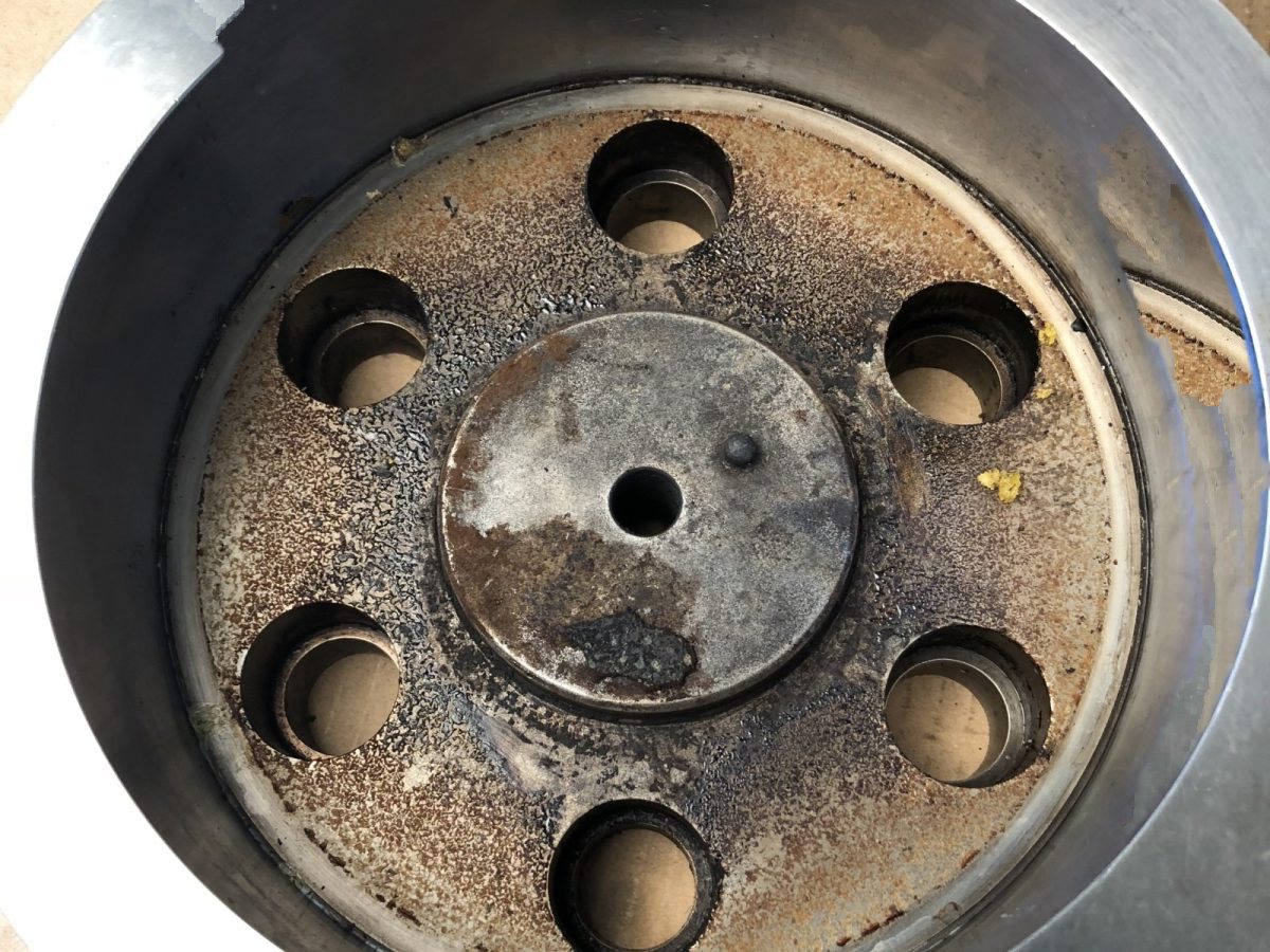 Food extrusion die plate with every aperture plugged by carbonised product