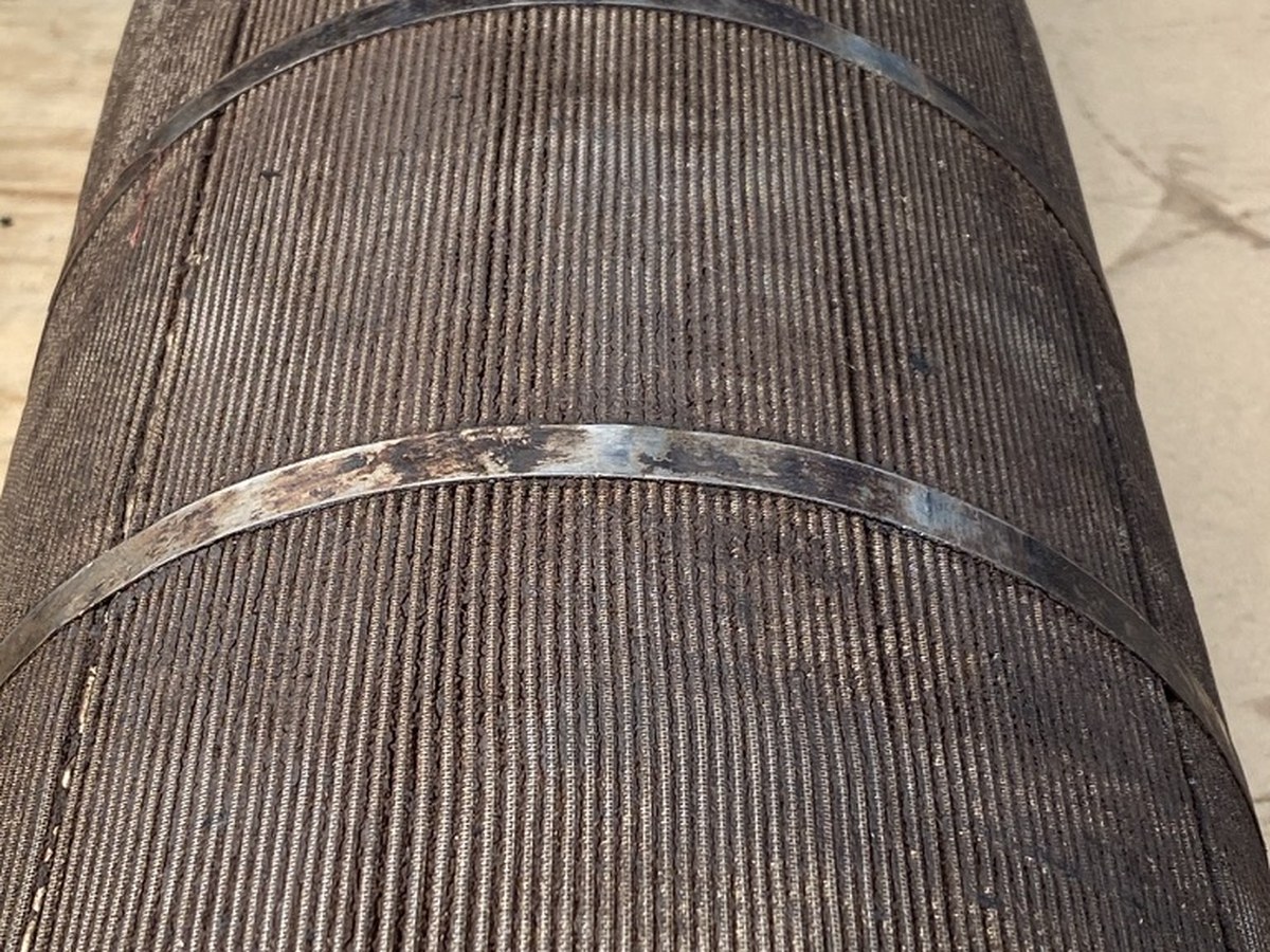 Pleated stainless mesh filter element blinded solid with carbonised residue